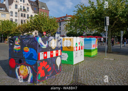 Bunte Graffiti auf Beton Poller Blöcke oder Hindernisse gemalt von Terroranschlägen, am Burgplatz in der Altstadt von Düsseldorf zu schützen. Stockfoto