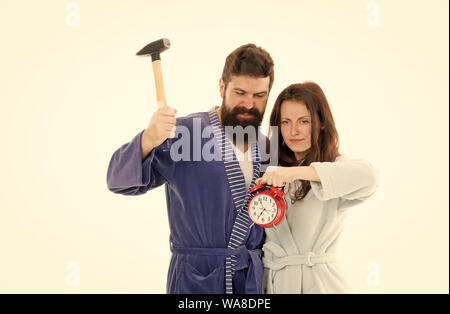 Am frühen morgen Angst. Können sie loswerden in diesem nervigen Wecker. Paar in Bademänteln, Wecker und Aufenthalt zu Hause zu vernichten. Brechen von Regeln. Mann mit dem Hammer beat Wecker. Hasserfüllt Klang. Stockfoto