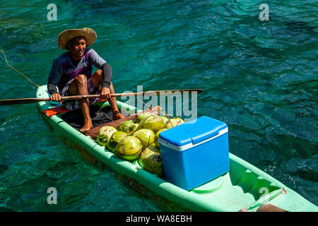 Ein lokaler Mann verkauf Buko Saft und kalte Getränke aus einem kleinen Boot, Cadloc Lagune, El Nido, Palawan, Philippinen Stockfoto