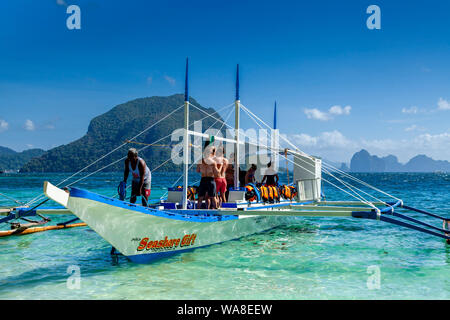 Touristen auf einem traditionellen hölzernen Banca Boot, Pasandigan Strand, El Nido, Palawan, Philippinen Stockfoto