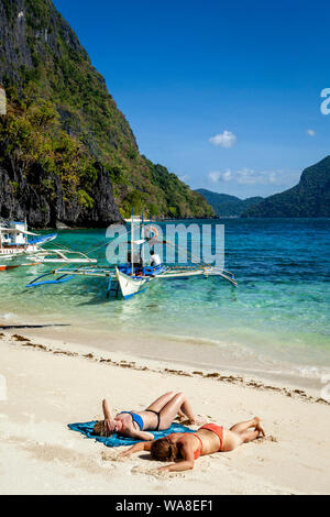 Weibliche Touristen Sonnenbaden auf Pasandigan Strand, El Nido, Palawan, Philippinen Stockfoto