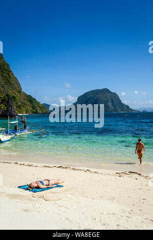 Weibliche Touristen Sonnenbaden auf Pasandigan Strand, El Nido, Palawan, Philippinen Stockfoto