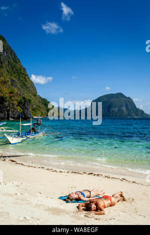 Weibliche Touristen Sonnenbaden auf Pasandigan Strand, El Nido, Palawan, Philippinen Stockfoto