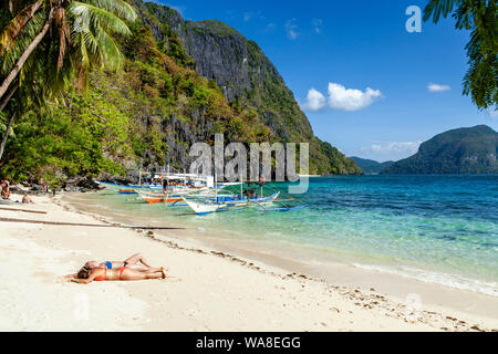 Weibliche Touristen Sonnenbaden auf Pasandigan Strand, El Nido, Palawan, Philippinen Stockfoto