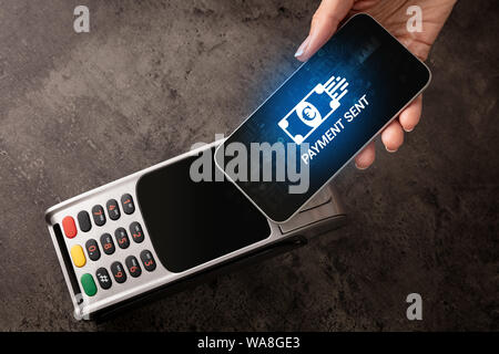 Hand bezahlen mit digitale Währung vom Smartphone Stockfoto