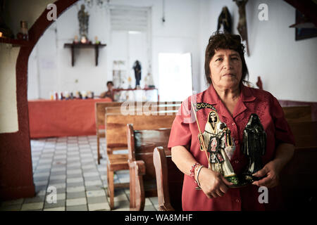 Anhänger von Nuestra Señora de la Santa Muerte (Unsere Liebe Frau von Heiligen Tod) besuchen Sie die Iglesia Santuario Nacional del Angel de la Santa Muerte in Tepito, Mexiko Stadt. Santa Muerte ist der Schutzpatron der Verbrecher, Prostituierte, Drogenabhängige, und alle, die von der Gesellschaft übersehen. Eine Personifikation des Todes, ist sie mit Heilung, Schutz und sichere Lieferung ins Jenseits von ihrer Anhänger. Stockfoto
