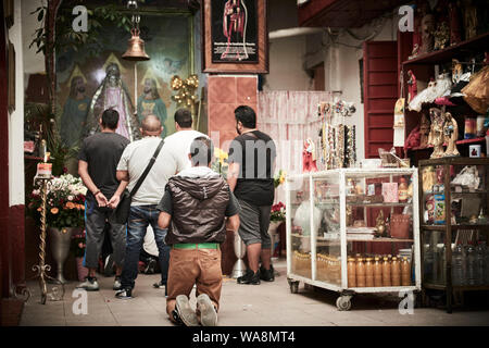 Anhänger von Nuestra Señora de la Santa Muerte (Unsere Liebe Frau von Heiligen Tod) besuchen Sie die Iglesia Santuario Nacional del Angel de la Santa Muerte in Tepito, Mexiko Stadt. Santa Muerte ist der Schutzpatron der Verbrecher, Prostituierte, Drogenabhängige, und alle, die von der Gesellschaft übersehen. Eine Personifikation des Todes, ist sie mit Heilung, Schutz und sichere Lieferung ins Jenseits von ihrer Anhänger. Stockfoto