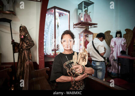 Anhänger von Nuestra Señora de la Santa Muerte (Unsere Liebe Frau von Heiligen Tod) besuchen Sie die Iglesia Santuario Nacional del Angel de la Santa Muerte in Tepito, Mexiko Stadt. Santa Muerte ist der Schutzpatron der Verbrecher, Prostituierte, Drogenabhängige, und alle, die von der Gesellschaft übersehen. Eine Personifikation des Todes, ist sie mit Heilung, Schutz und sichere Lieferung ins Jenseits von ihrer Anhänger. Stockfoto