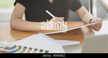 Nahaufnahme der jungen weiblichen Graphic Designer arbeiten an ihrem Projekt in komfortablen Büro Stockfoto