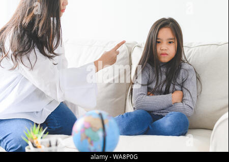 Wütend asiatischen Mutter sitzen mit kleinen Tochter, Mama schimpft für Disziplin schlechtes Verhalten kapriziöses Kind, Familie Generationen Probleme, misunderstandin Stockfoto