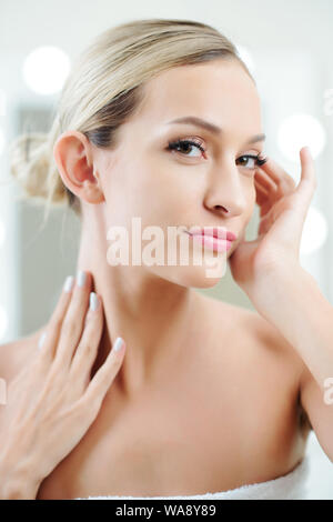 Wunderschöne junge Frau genießen das schöne, makellose taufrische Haut berühren. Stockfoto