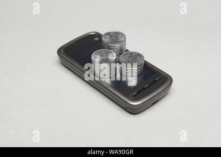 Stapel von indischen Münzen auf einem Smartphone Stockfoto
