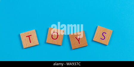 Das Wort Spielzeug, Dinkel mit hölzernen Buchstabensteine über blauen Hintergrund. Ansicht von oben Stockfoto