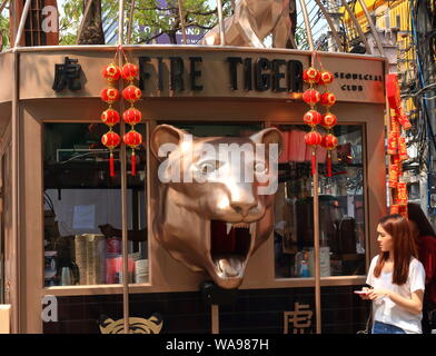 Schöne Dame gehen und bei Fire Tiger, das ist eine Erfrischung im Siam Square Shopping Center, Bangkok stall suchen, Thailand Stockfoto