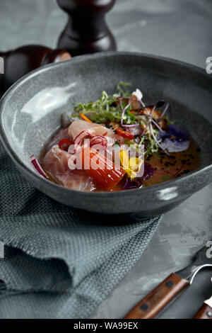 Traditionelle peruanische Küche ceviche von Seebarsch. - Nahaufnahme, Low Key, grauen Hintergrund. Ansicht von oben kopieren Raum Stockfoto