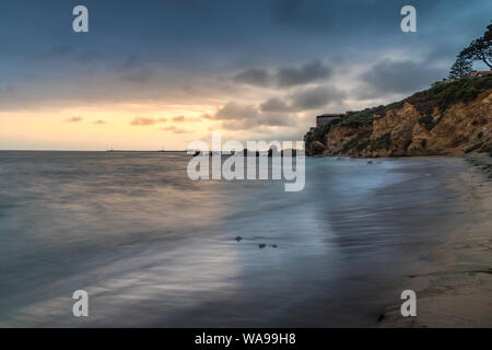 Schöne lange Belichtung geschossen von kleinen Corona Del Mar Strand bei Sonnenuntergang mit sanften Wellen auf das Ufer und hohen Klippen im Hintergrund, Coro Stockfoto