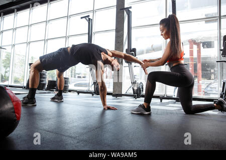 Eine muskulöse Athleten, trainieren Sie im Fitnessraum. Gymnastik, Training, Fitness Workout Flexibilität. Aktiven und gesunden Lebensstil, Jugend, Bodybuilding. Übungen für Gleichgewicht. Stockfoto