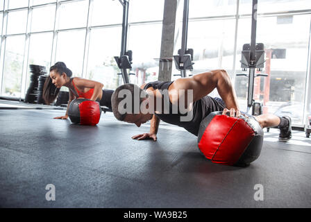 Eine muskulöse Athleten, trainieren Sie im Fitnessraum. Gymnastik, Training, Fitness Workout Flexibilität. Aktiven und gesunden Lebensstil, Jugend, Bodybuilding. Übungen zusammen, Ausbildung in Push-ups. Stockfoto