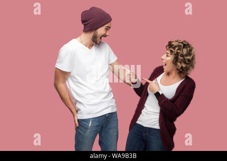 Es ist Sie! Seitenansicht Portrait von glücklich überrascht paar Freunden im lässigen Stil stehen, woman pointing Finger mit geöffnetem Mund und Excite Mann Stockfoto
