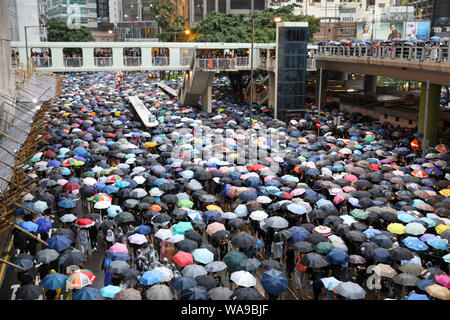 Hong Kong. 18 Aug, 2000. Große Zahl von Demonstranten halten Regenschirme auf eine nicht autorisierte März bei Regen marschieren durch die Straßen von Causeway Bay, die Organisatoren behaupten, mehr als 1,7 Millionen Menschen besucht. 18 August 2019 Credit: David Coulson/Alamy leben Nachrichten Stockfoto