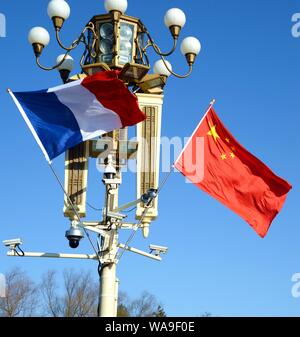 ------ Chinesische und Französische Nationale Fahnen flattern auf einen Laternenpfahl vor dem Tian'anmen Podium während des Besuchs des französischen Präsidenten Emmanuel Makro Stockfoto