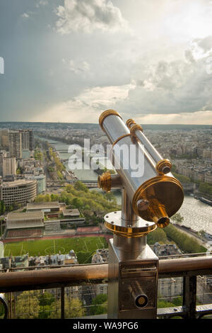 Münz-Teleskop auf dem Eiffelturm Aussichtsplattform. Auf der Suche nach Südwesten entlang der Seine und mit Regen Wolken Dusche. Paris, Frankreich Stockfoto