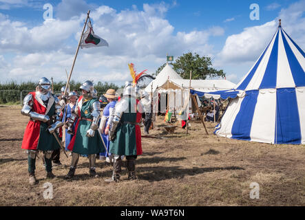 Die Teilnehmer tragen Kleidung und Rüstung in die lebendige Geschichte Camp bei Bosworth Battlefield Re-enactment Veranstaltung, Leicestershire, Großbritannien Stockfoto