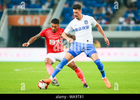 Deutsche Fußballspieler Sandro Wagner, rechts, von Tianjin TEDA passt den Ball gegen den brasilianischen Fußballspieler Paulinho von Guangzhou Evergrande Taobao Stockfoto