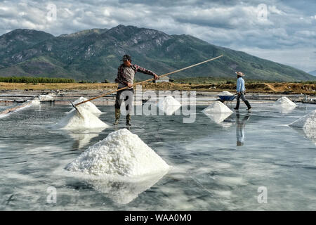 Nha Trang, Vietnam - 16. August: Männer Salz in Stapeln auf dem Hon Khoi Salz Felder am 16. August 2018 in Nha Trang, Vietnam. Stockfoto