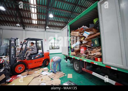 Ein chinesischer Arbeiter sortiert Recycling Abfall, der auf einer Distribution Center der erneuerbaren Energien Abfälle aus Behälter bereitgestellt werden, um das neue Müll sortieren s gerecht zu werden gesammelt Stockfoto