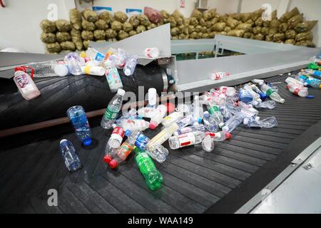 Ein chinesischer Arbeiter sortiert Recycling Abfall, der auf einer Distribution Center der erneuerbaren Energien Abfälle aus Behälter bereitgestellt werden, um das neue Müll sortieren s gerecht zu werden gesammelt Stockfoto