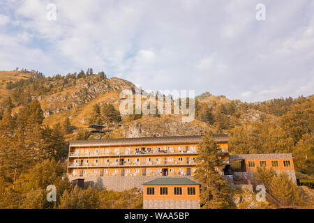 Luftaufnahme von Holzhäuser und Hotels im Altai Gebirge zwischen den Felsen und gelbe Bäume für Entspannung und Unterkunft während touristische Ausflüge Stockfoto