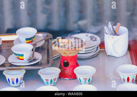 Traditionelle Tasse äthiopischen Kaffee mit aromatischen Essenz serviert. Festakt mit Weihrauch, Weihrauch und Myrrhe, entzündet durch eine heisse Kohle zu Produ Stockfoto
