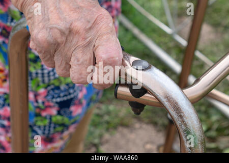 Nahaufnahme der älteren Frau, die mit Hilfe von Walker. Alte kranke Frau 90 Jahre im Krankenhaus. Stockfoto