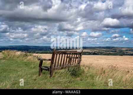 Holzbank mit Blick auf ein Tal in den Cotswolds in der Nähe von Burford. Stockfoto