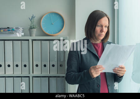 Betroffenen Geschäftsfrau lesen Business Report Papiere im Büro, finanzielle Daten Analyse und strategische Planung Konzept Stockfoto