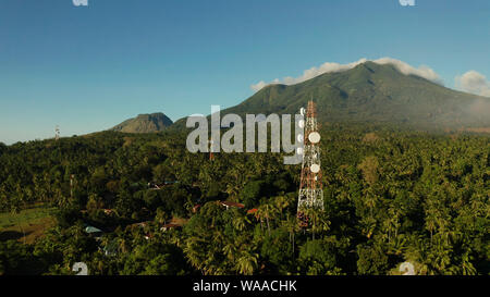 Antennen und Mikrowelle link Gerichte der Mobilfunk- und TV-Sender auf Telekommunikation Türme mit Berge und Regenwald. Camiguin, Philippinen Stockfoto