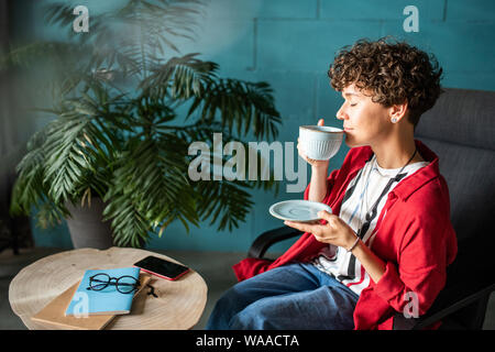 Junge Frau genießen Sie aromatischen Kaffee oder Tee während riecht es Stockfoto