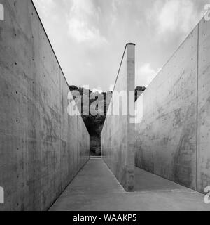 Ein Schwarz-Weiß-Foto des von Beton ummauerten Eingangs zum Lee Ufan Museum in Naoshima, Japan Stockfoto