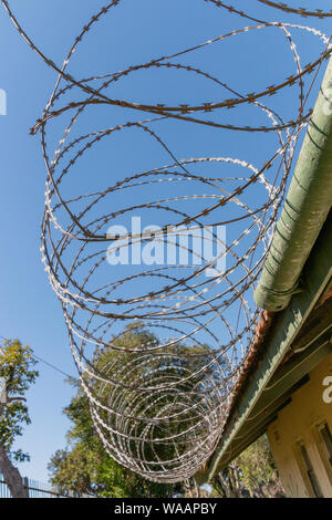 Eine Nahaufnahme von großen Metall Stacheldraht auf einem alten Gebäude Dach Stockfoto