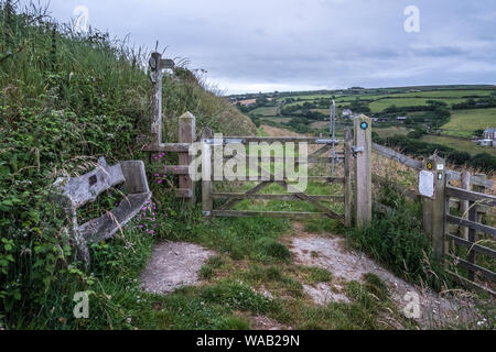 Eine Bank-, Tor- und Schilder mit üppigen grünen Landschaft Blick auf den Pembrokeshire Coast Path, Wales Stockfoto