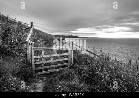 Eine schwarze und weiße Landschaft Foto von einem Tor auf der atemberaubenden Pembrokeshire Coast Path, Wales Stockfoto