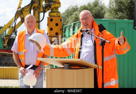 Salchow, Deutschland. 19 Aug, 2019. Ronald Normann (l), Leiter der Abteilung an der Autobahn das Landesamt für Straßenbau und Verkehr M-V, und Christian Pegel (SPD), Verkehrsminister, begrüßen die Gäste mit dem zeremoniellen Start der Bauarbeiten auf der A20 Autobahn Ostsee entlassen. In der ersten Bauphase, Pfähle in den Boden und etwa 80 Meter von der Fahrbahn in Richtung Rostock und Lübeck umgebaut angetrieben werden sollen, Teile des Trebeltal Brücke sind auch repariert werden. Quelle: Bernd Wüstneck/dpa-Zentralbild/dpa/Alamy leben Nachrichten Stockfoto