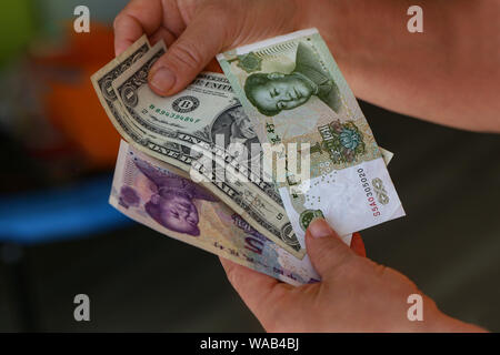 Dollar vs Yuan. Dollar und Yuan in den Händen Stockfoto
