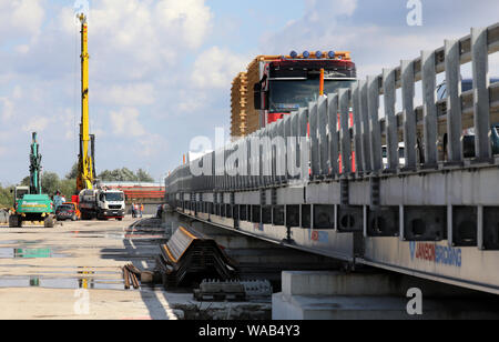 Salchow, Deutschland. 19 Aug, 2019. Eine große Bohrinsel steht neben dem Behelfsmäßigen Brücke an dem zeremoniellen Start der Bauarbeiten auf der A20 Autobahn Ostsee entlassen. In der ersten Bauphase, Pfähle in den Boden und etwa 80 Meter von der Fahrbahn in Richtung Rostock und Lübeck umgebaut angetrieben werden sollen, Teile des Trebeltal Brücke sind auch repariert werden. Quelle: Bernd Wüstneck/dpa-Zentralbild/dpa/Alamy leben Nachrichten Stockfoto