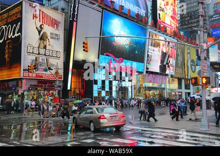 NEW YORK, USA - 10. JUNI 2013: die Menschen besuchen regnerischen Times Square in New York. Den Platz an der Kreuzung von Broadway und 7. Avenue hat einige 39 Millionen visi Stockfoto