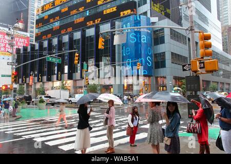 NEW YORK, USA - 10. JUNI 2013: die Menschen besuchen regnerischen Times Square in New York. Den Platz an der Kreuzung von Broadway und 7. Avenue hat einige 39 Millionen visi Stockfoto