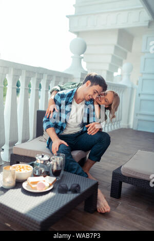 Frau umarmt man beim Frühstück auf dem Balkon Stockfoto