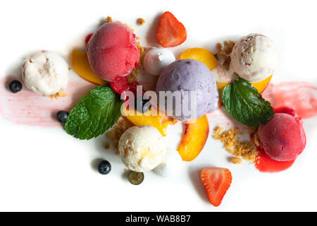 Bunte fruchtige Platte des Eis Schaufeln mit cremiger blueberry Ice Cream Erdbeere und Pfirsich Sorbets und frische Früchte Slices auf weiße Platte Stockfoto