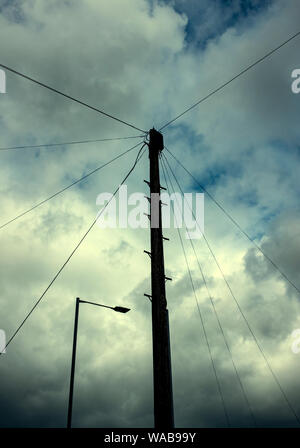 Holz- Telegraphenmast mit street Licht und bedecktem Himmel UK Stockfoto